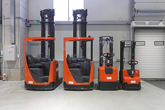 forklift operator moving pallets of goods in distribution center